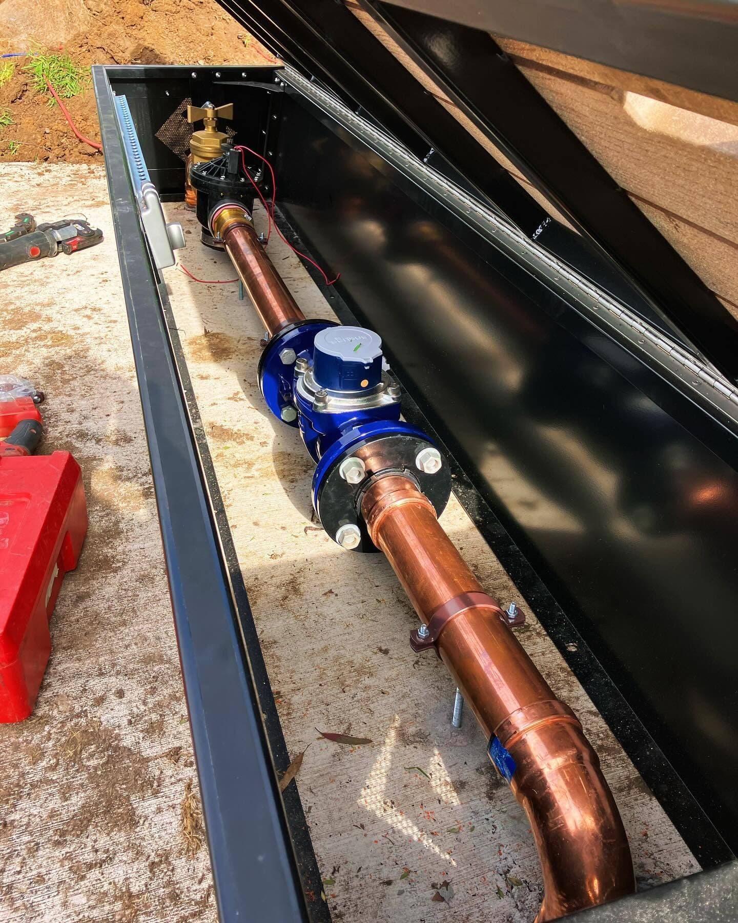 Copper water service pipework and meter assembly within the bench seat enclosure