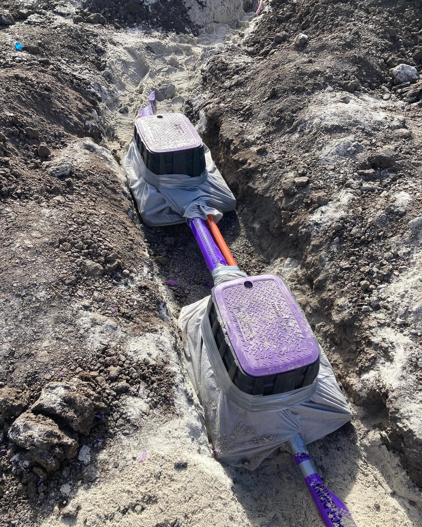 Underground valve boxes, recycled-water pipework and orange control conduit