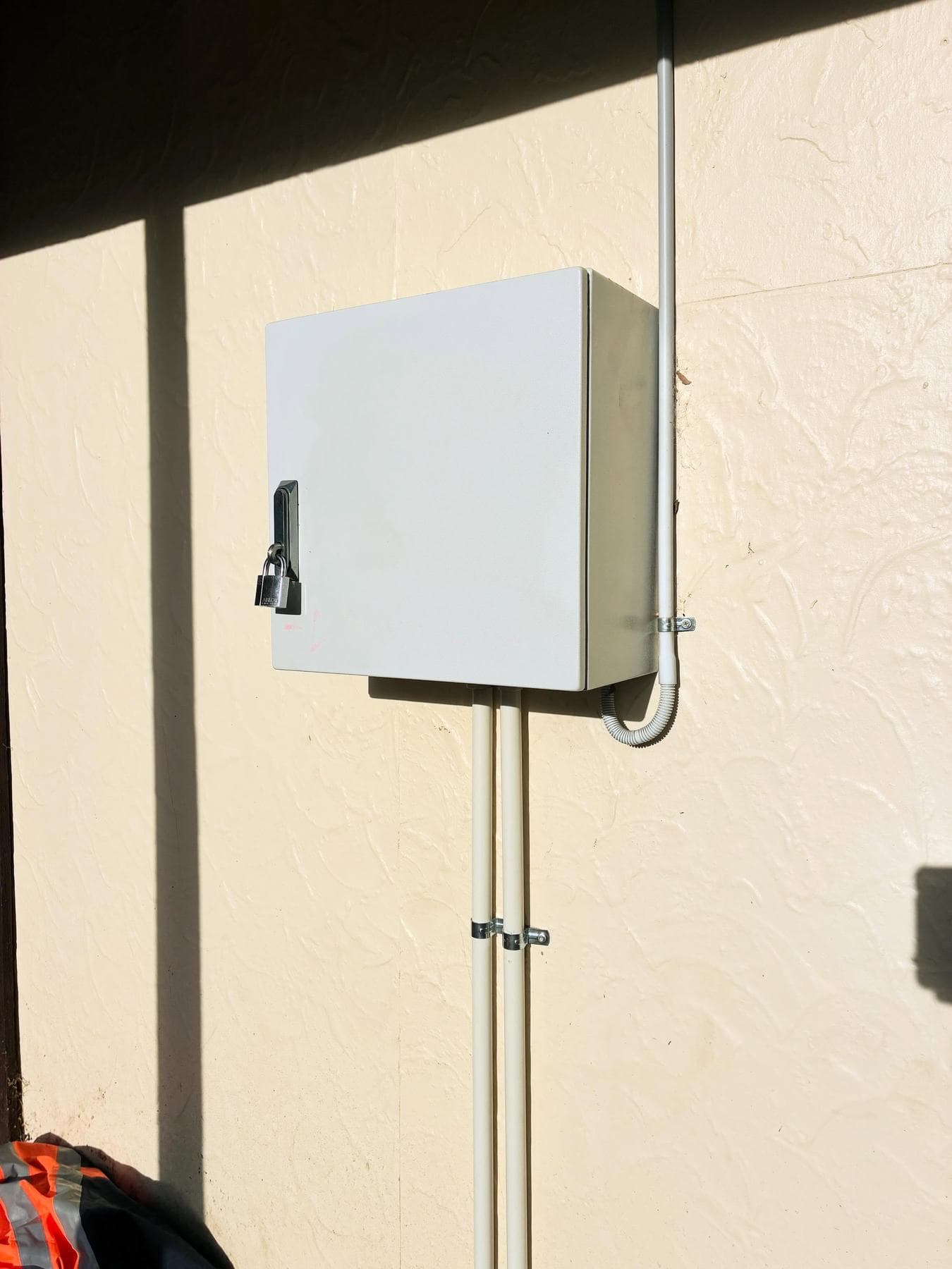 Locked irrigation controller cabinet mounted to an external wall