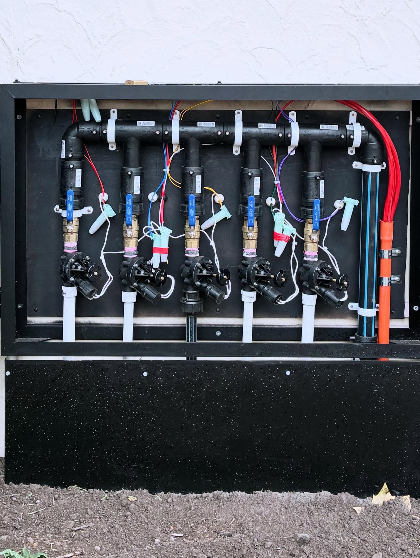 Valve manifold cabinet with five solenoid valves and control wiring mounted to a wall