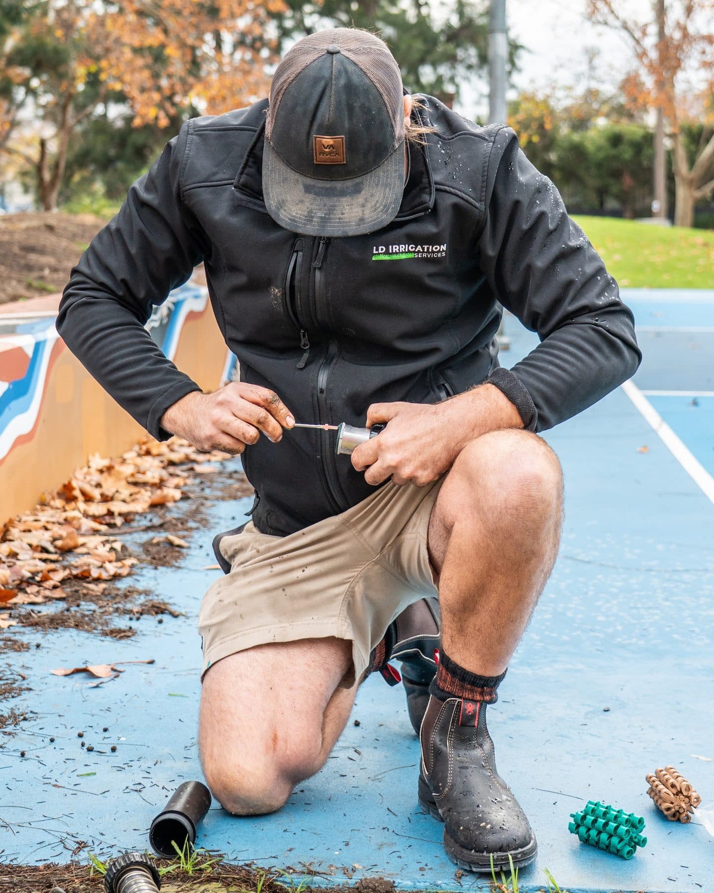 LD Irrigation Services technician repairing an irrigation component on site